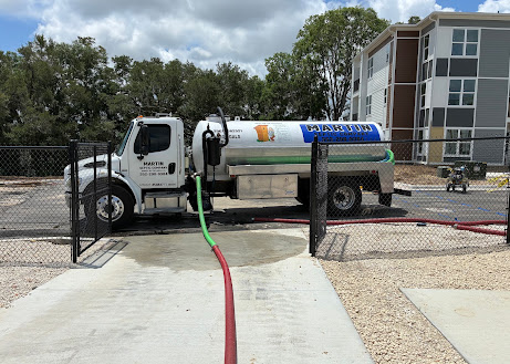 Martin Septic truck pumping at a commercial property, hoses run to the tank