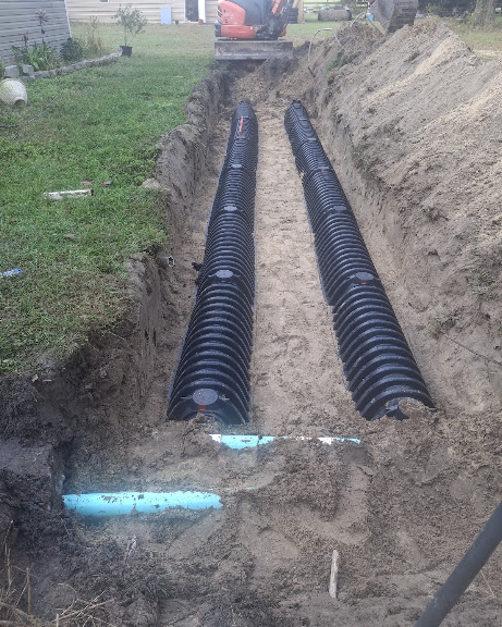 Open drainfield trench with chambers set before backfill